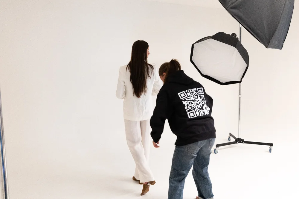 Fotograf klargjør en modell under fotografering i Apex sitt studio