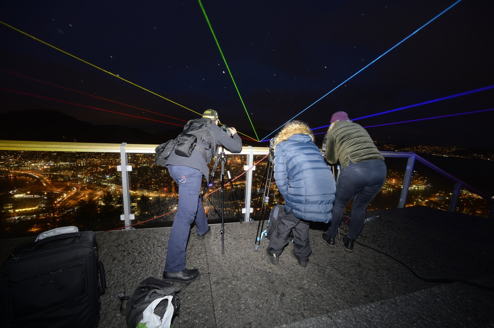 Kursdeltakere fotograferer lysstråler over Bergen by om natten fra Fløyen, viser bruk av lang lukkerhastighet.