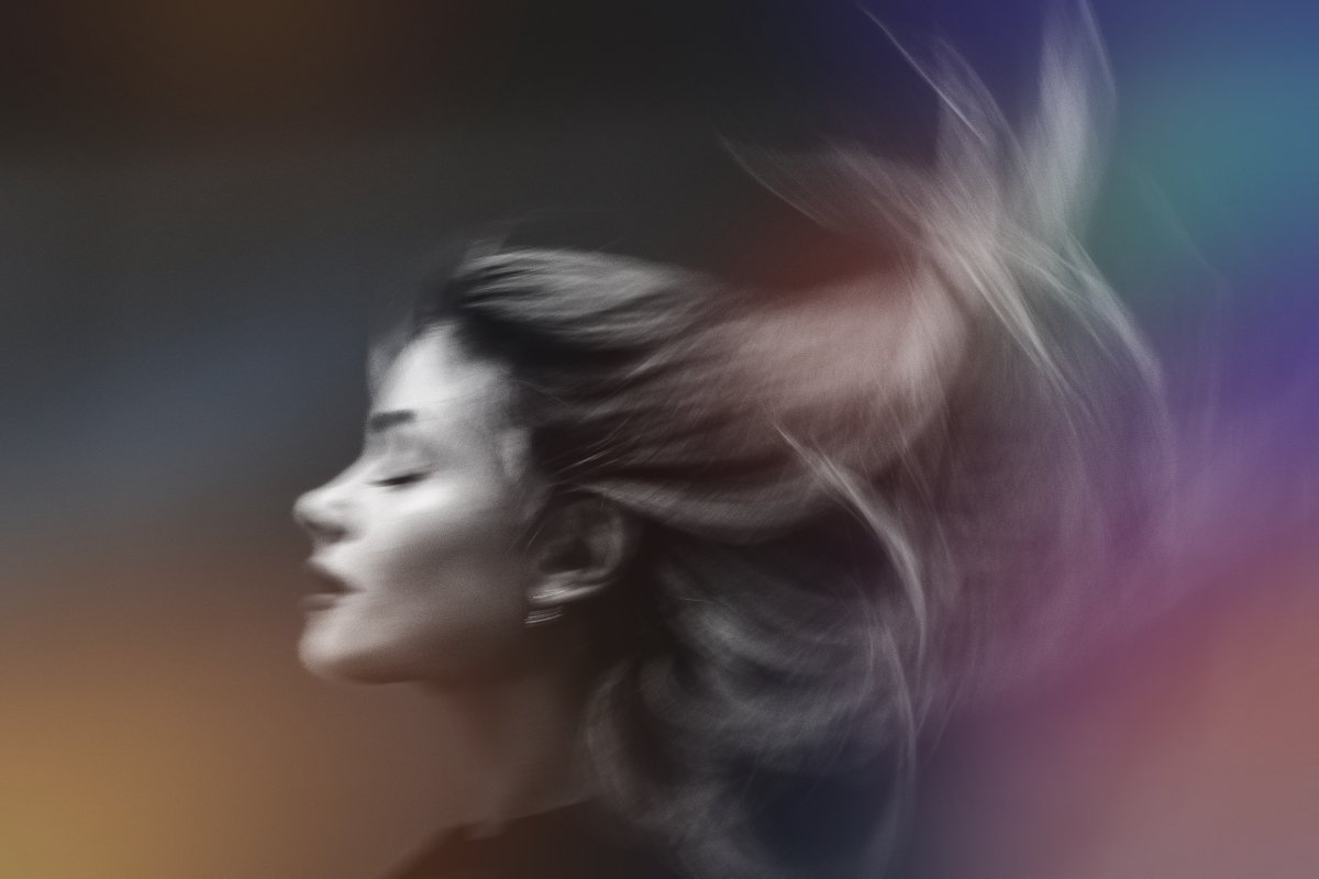 Kreativt portrett av modell med bevegelse i hår og mykt lys