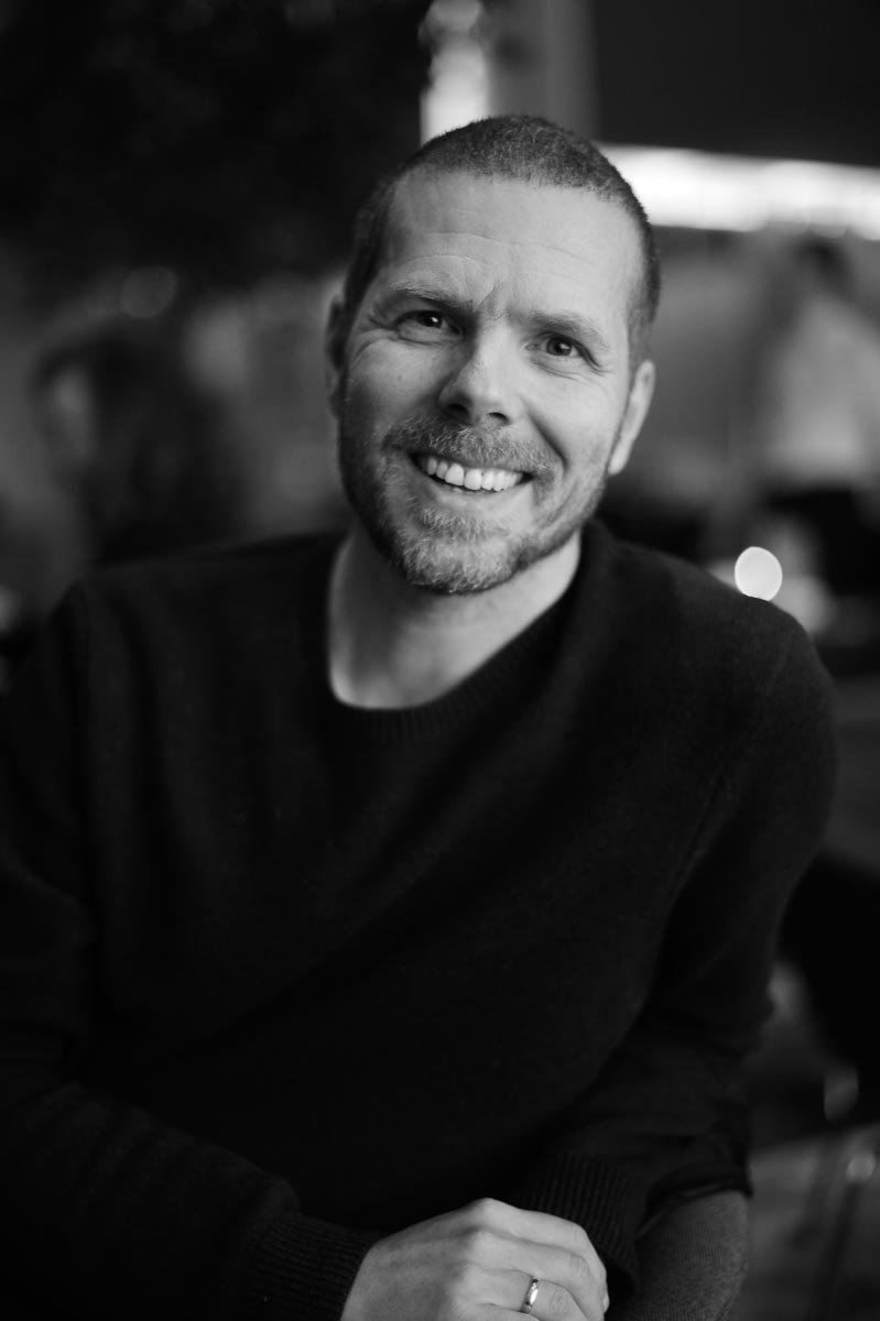 sort-hvitt portrett av mannlig kunstner i studio