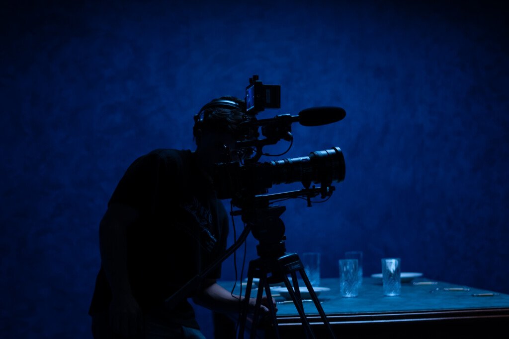 Videograf filmer live event med profesjonelt kamera i mørk setting – eventfilm Bergen